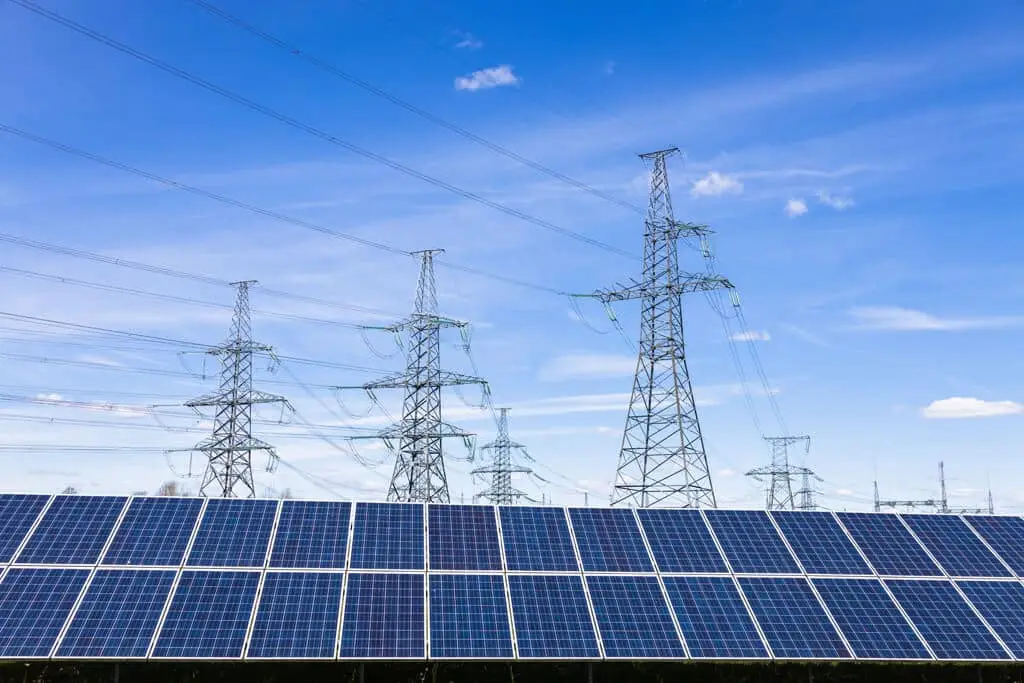 solar panels with electrical transmission towers and power lines